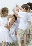 Bride and groom with children on beach