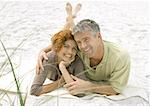 Mature couple lying on sand together