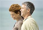 Mature couple smiling by seaside