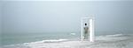 Man standing on beach, framed by doorframe