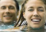 Couple in pool together, close-up of faces