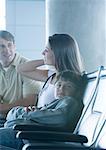 Family sitting in airport lounge, boy looking at camera
