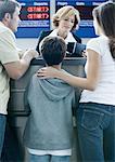 Family standing at airline check-in counter