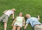Three children lying in grass