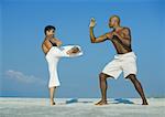 Two men practicing martial arts on beach