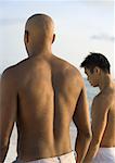 Two men standing on beach