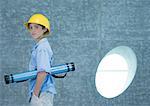 Boy holding document tube under arm and wearing hard hat