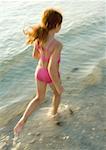 Girl running in surf at beach