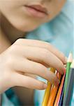 Child touching colored pencils