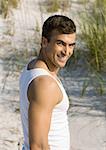 Man on beach, smiling at camera