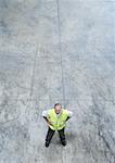 Factory worker standing with hands on hips, high angle view