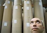 Man in front of rolls of paper in warehouse