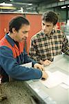 Manual worker and apprentice at work table