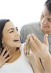 Man handing woman keys, woman smiling