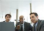 Three businessmen talking in airport