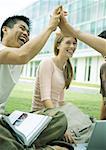 Students laughing and clasping hands on campus