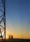 Nuclear cooling towers and electric wires and pylon at sunset