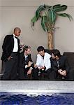 Men in Formal Wear Drinking Cocktails Poolside