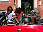 Couple Leaning on Car Full of Belongings