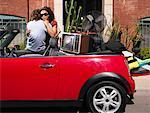 Couple Hugging by Car Full of Belongings