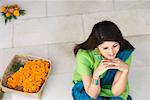 High angle view of a young woman sitting on the floor and smiling