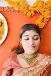 High angle view of a young woman lying on a mat with her eyes closed