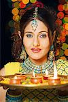 Portrait of a young woman holding a plate of religious offerings