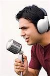 Nahaufnahme eines jungen Mannes in ein Mikrofon singen