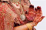 Mid section view of a bride showing her henna tattooed hands