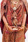 Mitte Schnittansicht einer Braut hält ein Idol von Lord Krishna