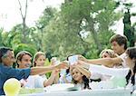 Fête d'anniversaire en plein air assisté par famille multi-générationnelle, tout le monde tinter les tasses