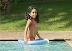 Little girl in swimming pool with floating ring