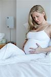 Femme enceinte dans le lit