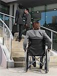 Man in Wheelchair Looking at Staircase
