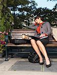 Woman Falling Asleep on Park Bench While Using Laptop Computer