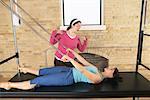 Woman Exercising With Pilates Instructor