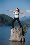 Woman Doing Yoga on Tree Stump