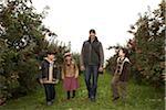 Man Walking in Orchard with Children