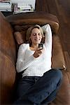 Femme à l'aide de téléphones cellulaires sur le canapé