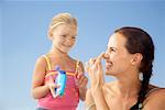 Girl Putting Sunscreen on Mother