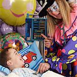 Clown Examining Child in Hospital Bed