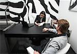 Businesswoman Sitting with Businessman at Desk