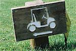 Wooden sign with golf cart and arrow