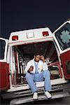 Médecin assis derrière l'Ambulance