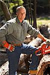 Man Cutting Wood With Chainsaw