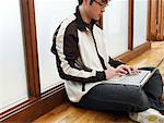 Man Sitting on Floor Using Laptop