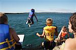 Kinder in Schwimmwesten Sprung in den See