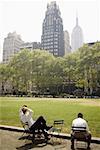 Three men sitting in a park, Chrysler Building, Manhattan, New York City, New York State, USA