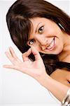 Portrait of a young woman making an OK sign and smiling