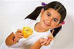 Portrait eines Mädchens holding ein Cupcake und ein Bonbon